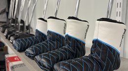 Putter headcovers lined up on the shelf