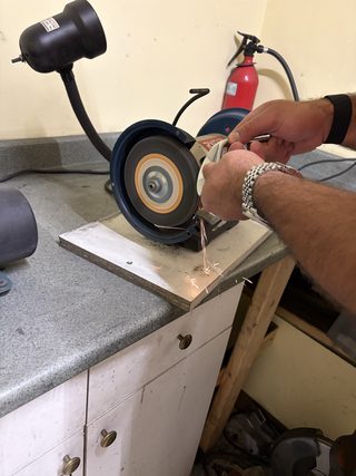 Belt sander mounted at the repair bench